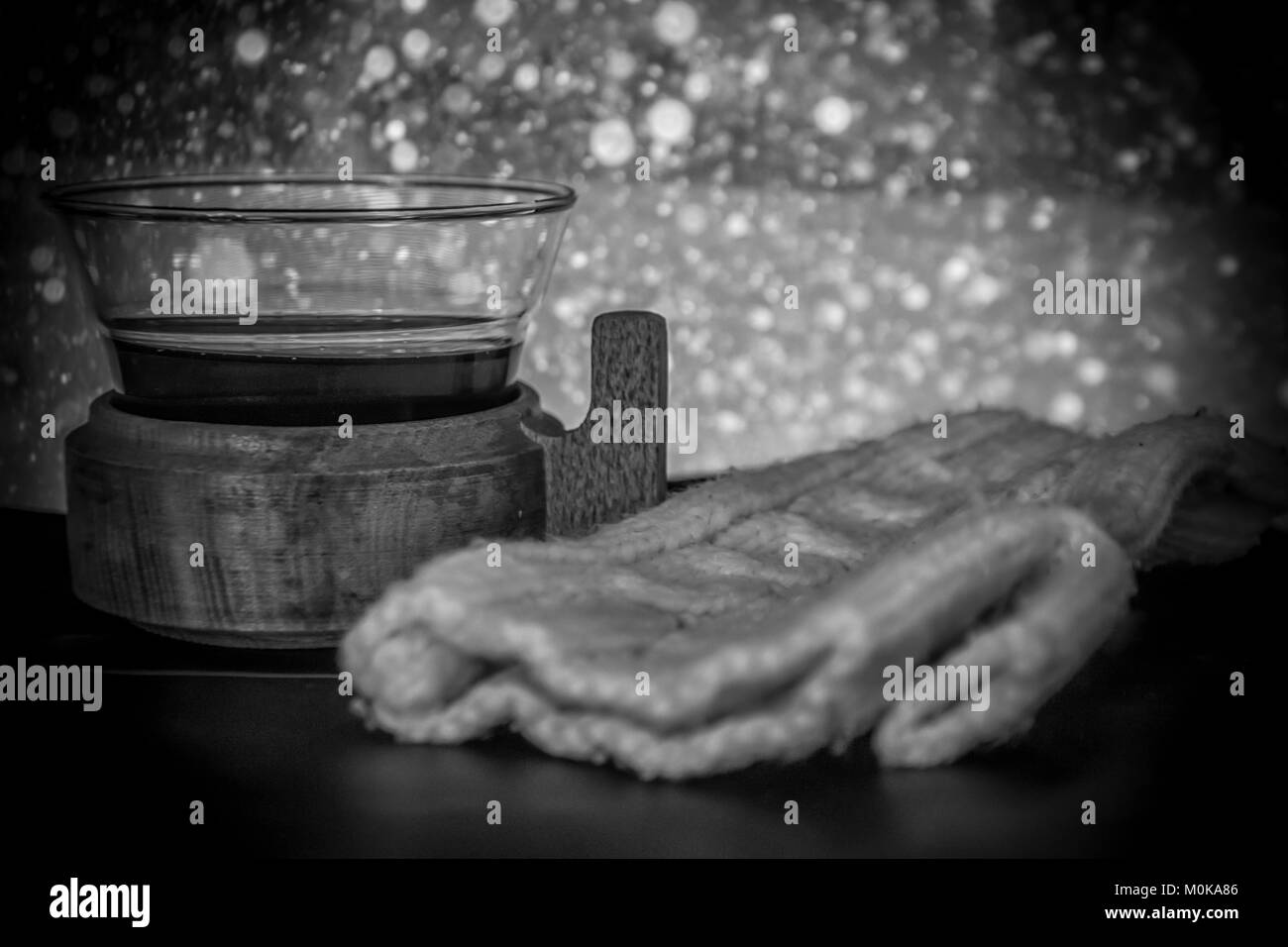 Photo en noir et blanc d'un verre de vin chaud et des gants Banque D'Images