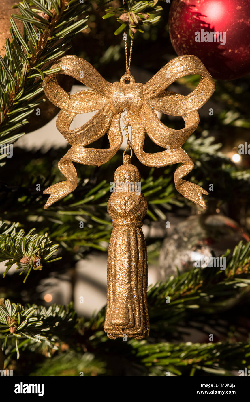 Golden tassel avec noeud sur l'arbre de Noël ; London, England Banque D'Images