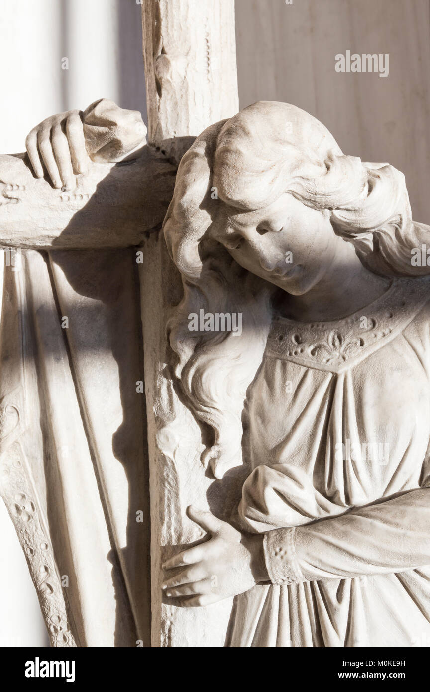 Statue d'un ange pur tenant une croix avec les yeux fermé Banque D'Images