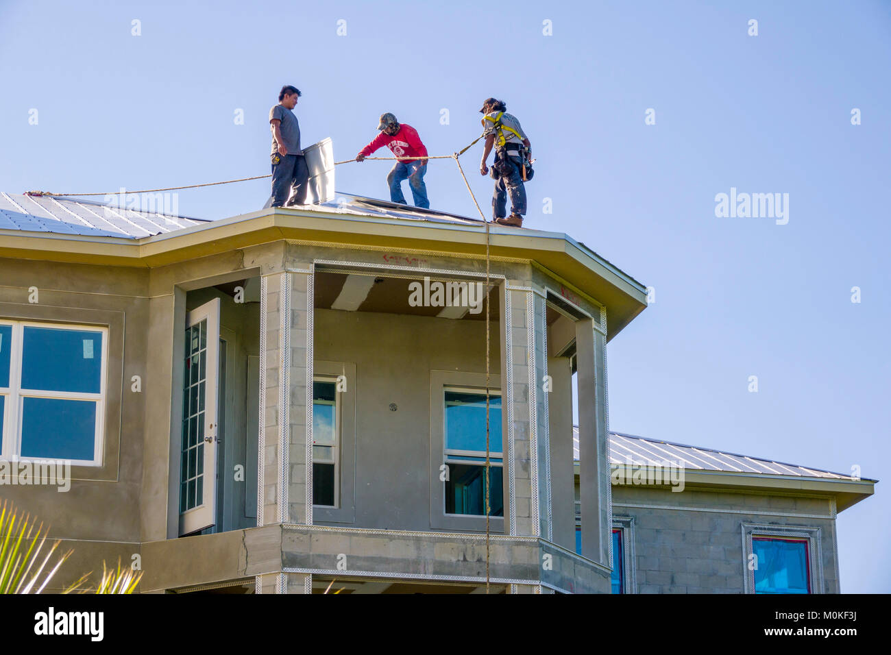 L'installation de travailleurs une toiture métallique au sommet d'une nouvelle construction d'habitation en copropriété Banque D'Images