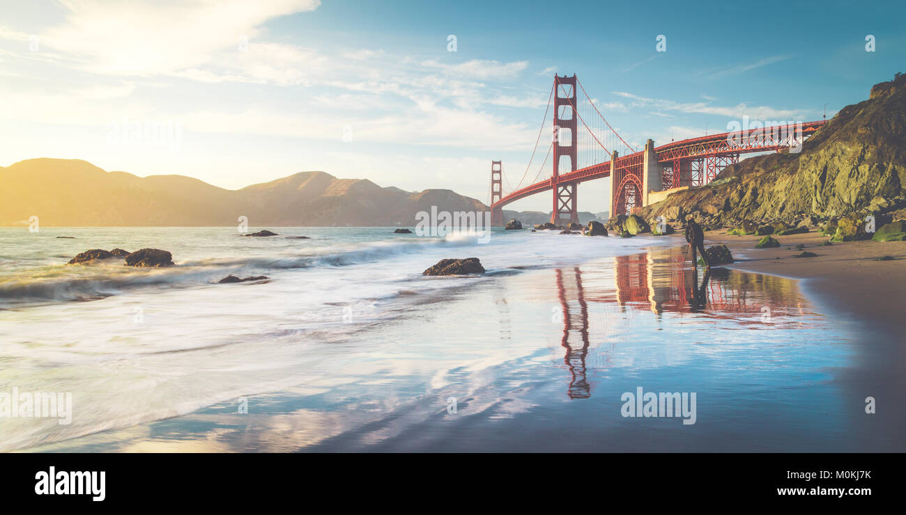 Classic vue panoramique de célèbre Golden Gate Bridge vu de scenic Baker Beach dans un beau soir d'or lumière sur une journée ensoleillée avec ciel bleu Banque D'Images