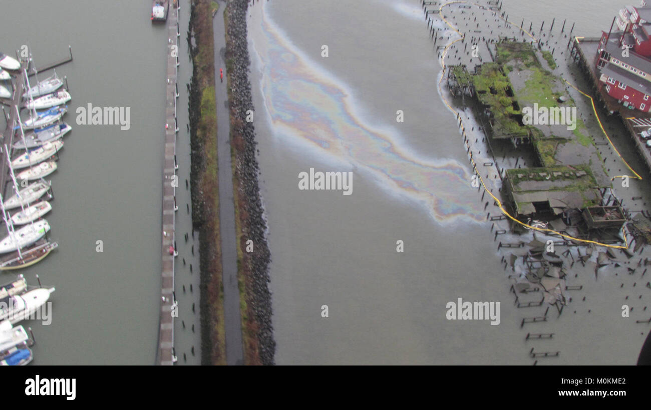 De confinement est mis autour de divers domaines autour d'une jetée délabrée pour empêcher la propagation d'un reflet brillant sur la surface de la rivière Columbia, à Astoria, Oregon, le 20 janvier 2018. Division de la gestion de l'incident de la Garde côtière canadienne sont sur les lieux de l'Astoria et diriger les efforts de nettoyage par le personnel contractuel de plongée mondiale et de récupération. La Garde côtière américaine Banque D'Images