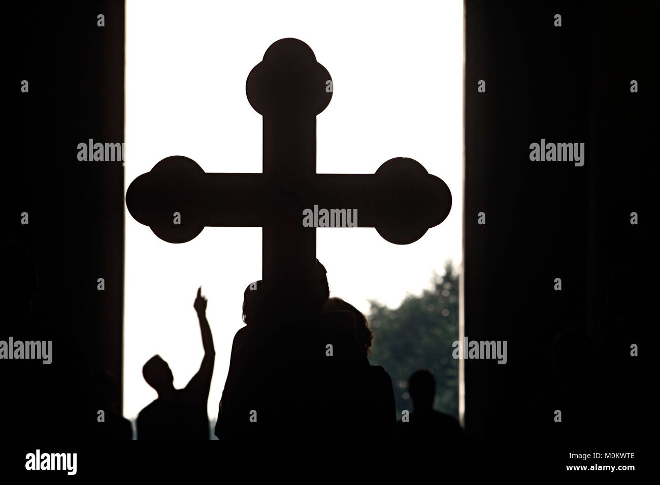 Croyant se dirigeant à silhouette de grand croix dans l'église Banque D'Images