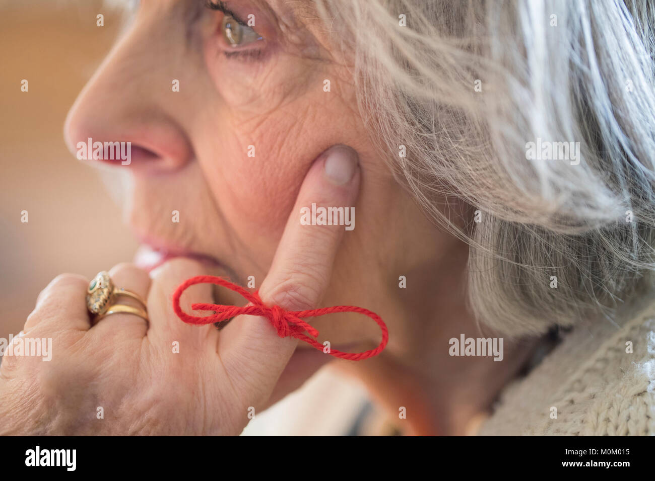Close Up of Senior Woman with String attaché autour du doigt comme rappel Banque D'Images