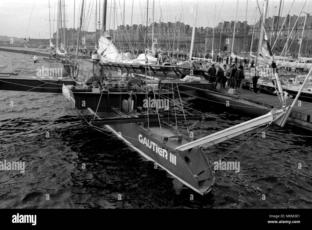 AJAXNETPHOTO. 1982. ST.MALO, FRANCE - Route du Rhum - le TRIMARAN HYDROPTÈRE GAUTIER III SKIPPÉ PAR JEAN YVES TERLAIN DANS BASSIN VAUBIN MARINA SE PRÉPARE POUR LE DÉPART. PHOTO:JONATHAN EASTLAND/AJAX REF:821007 11015  Banque D'Images