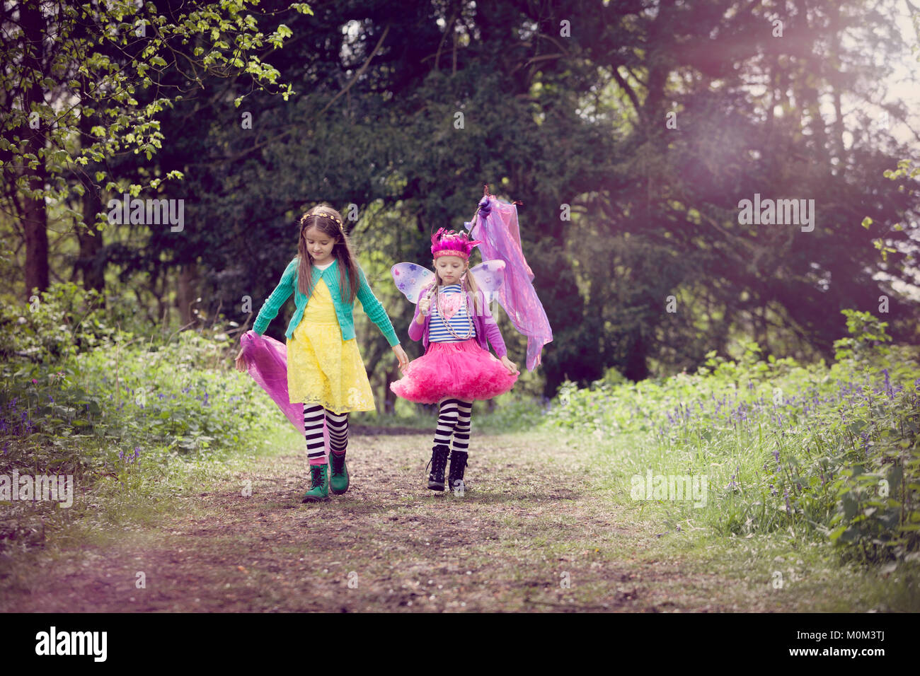 Deux enfants en robes colorées, marcher le long d'un chemin forestiers Banque D'Images