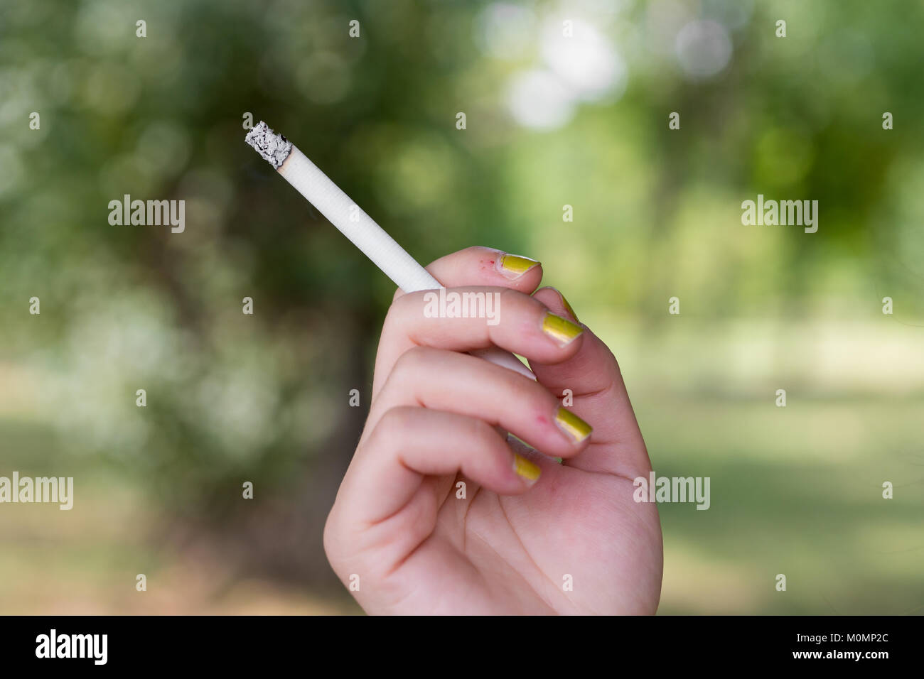 Femme fumant et tenant une cigarette dans sa main Banque D'Images