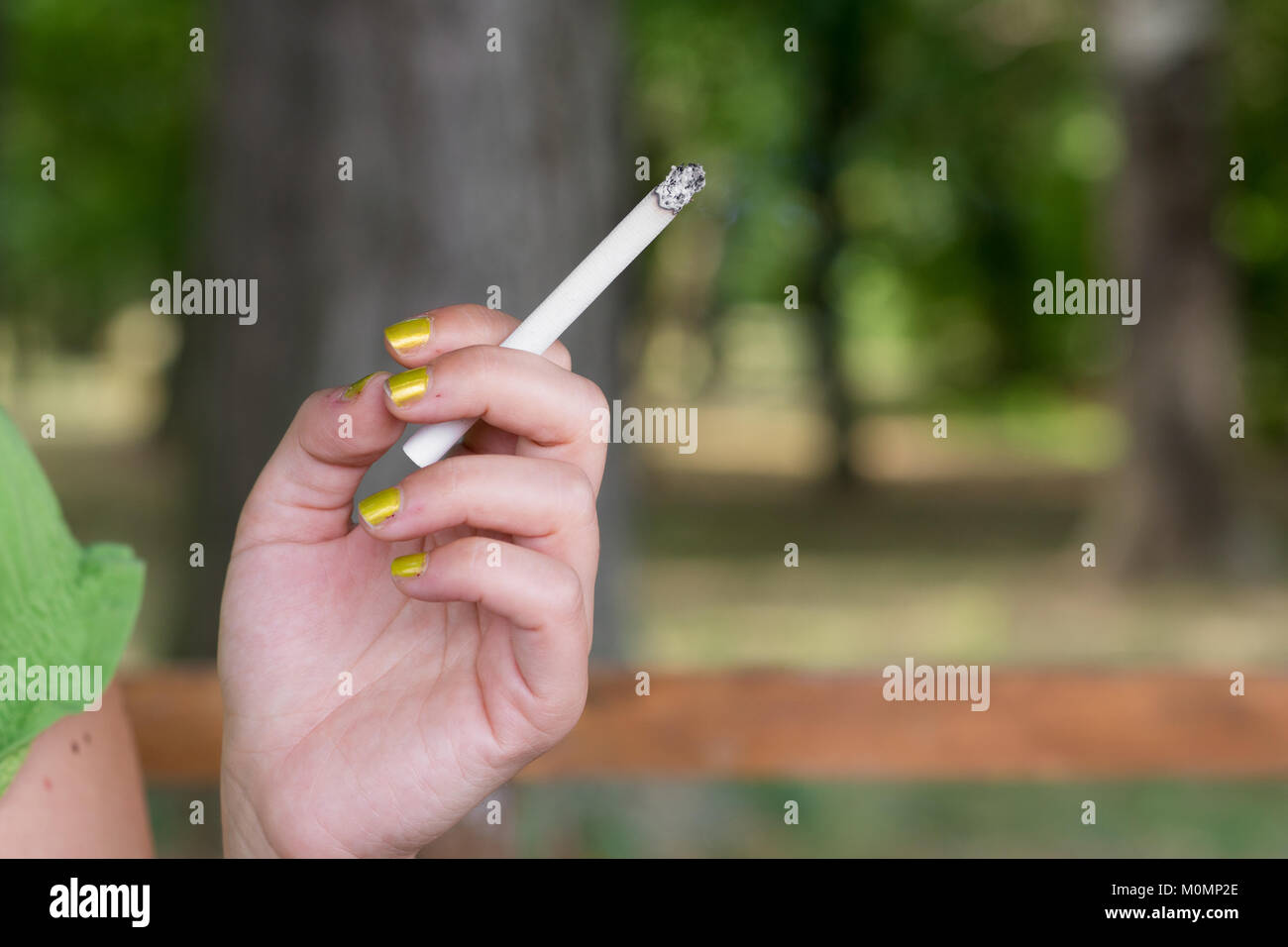 Femme fumant et tenant une cigarette dans sa main Banque D'Images