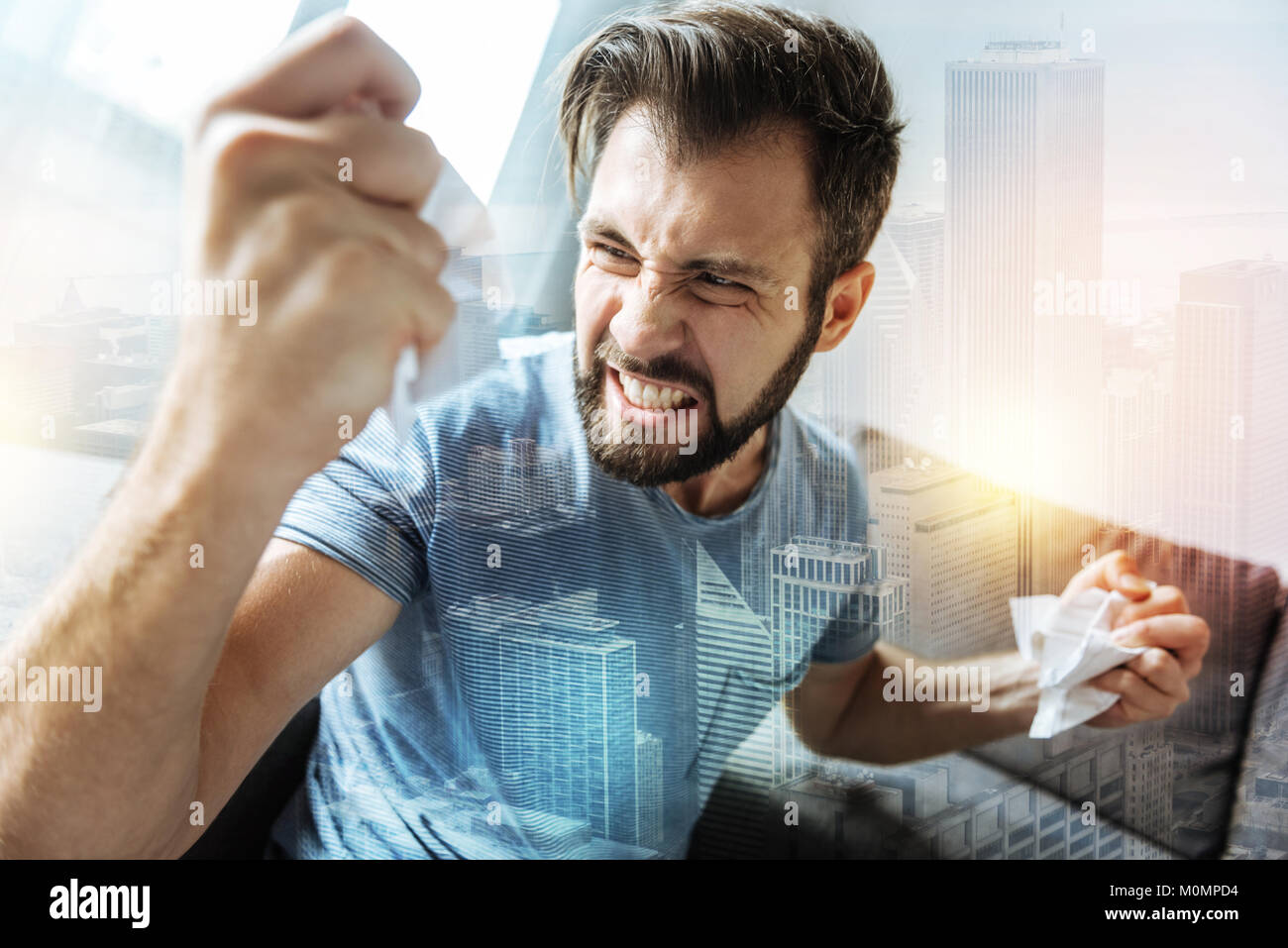 Homme Beardful snappish de déchirer le papier et se sentir mal lui-même. Banque D'Images