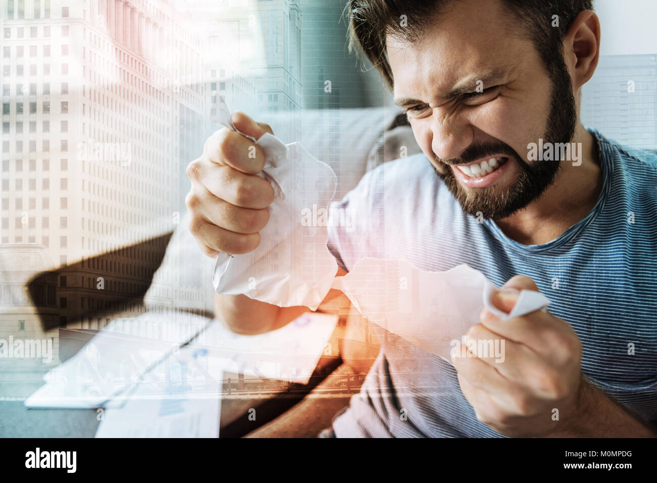 En colère contre l'homme stressante de déchirer le papier et la fusion. Banque D'Images