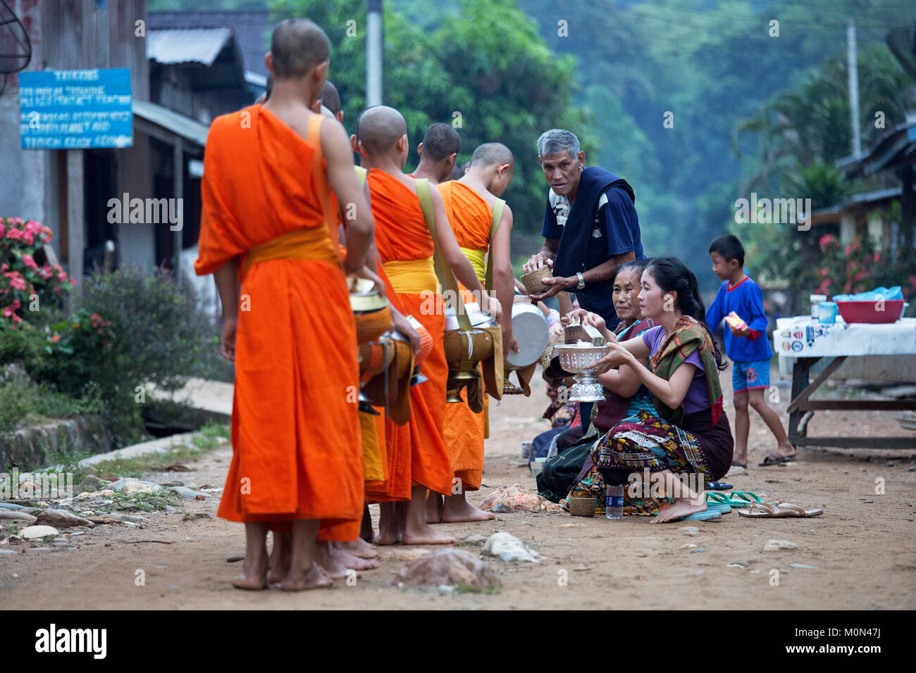 La collecte de l'aumône des moines au petit matin à Muang Ngoi, Nord du Laos Banque D'Images
