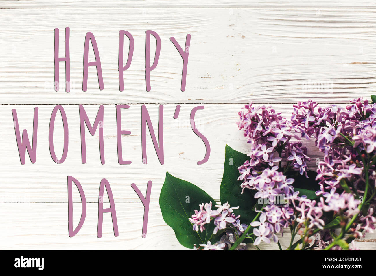 Bonne journée de la femme, signe de texte simple carte de vœux. belles fleurs lilas blanc rustique sur fond de bois. Vue de dessus de l'espace pour texte. Heureux mères Banque D'Images
