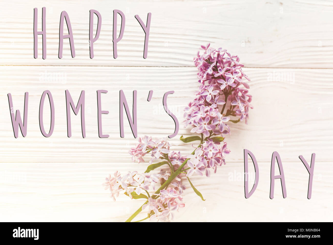Bonne journée de la femme, signe de texte simple carte de vœux. belles fleurs lilas blanc rustique sur fond de bois. Vue de dessus de l'espace pour texte. Heureux mères Banque D'Images