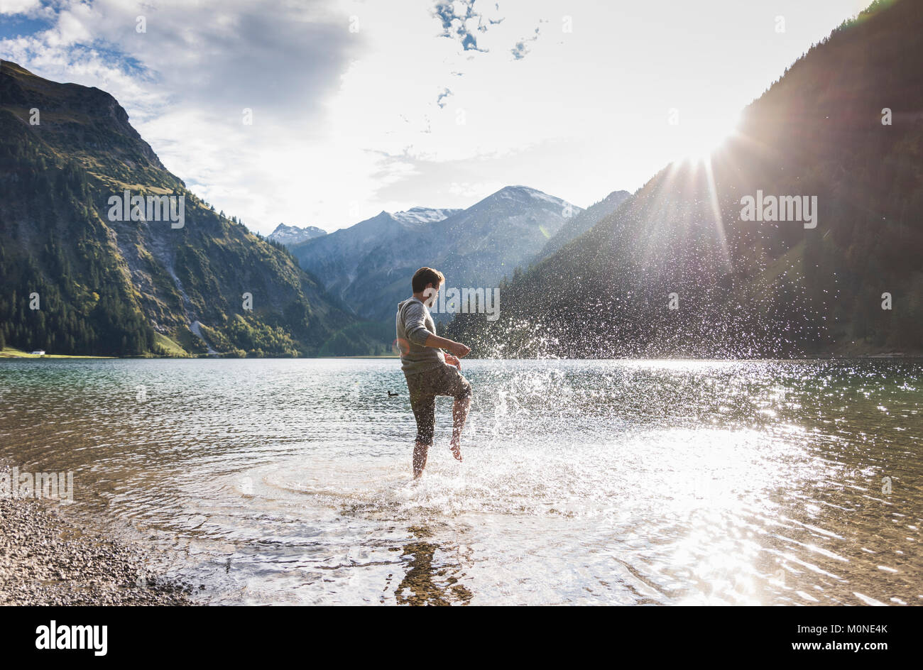 Autriche, Tyrol, randonneur splashing in Mountain Lake Banque D'Images