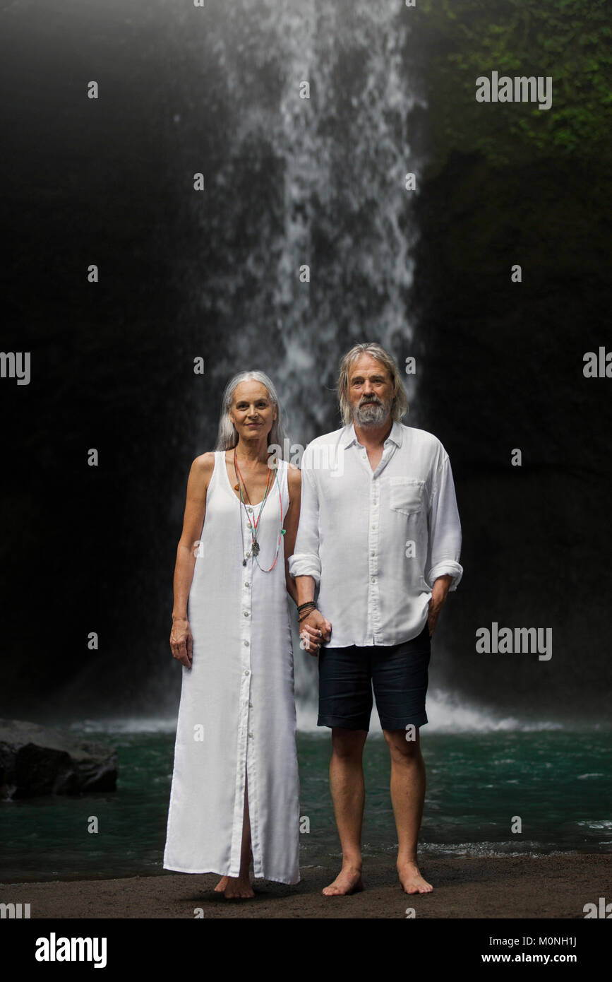 Romantic couple standing in front of cascade tropicale Banque D'Images Romantic couple standing in front of cascade tropicale Banque D'Images