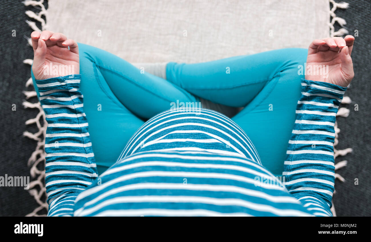 Vue supérieure de l'exercice pratique le yoga de la femme enceinte à la maison. Le yoga et la grossesse à l'intérieur concept de remise en forme. Images à faible contraste de l'ungraded avec natur Banque D'Images