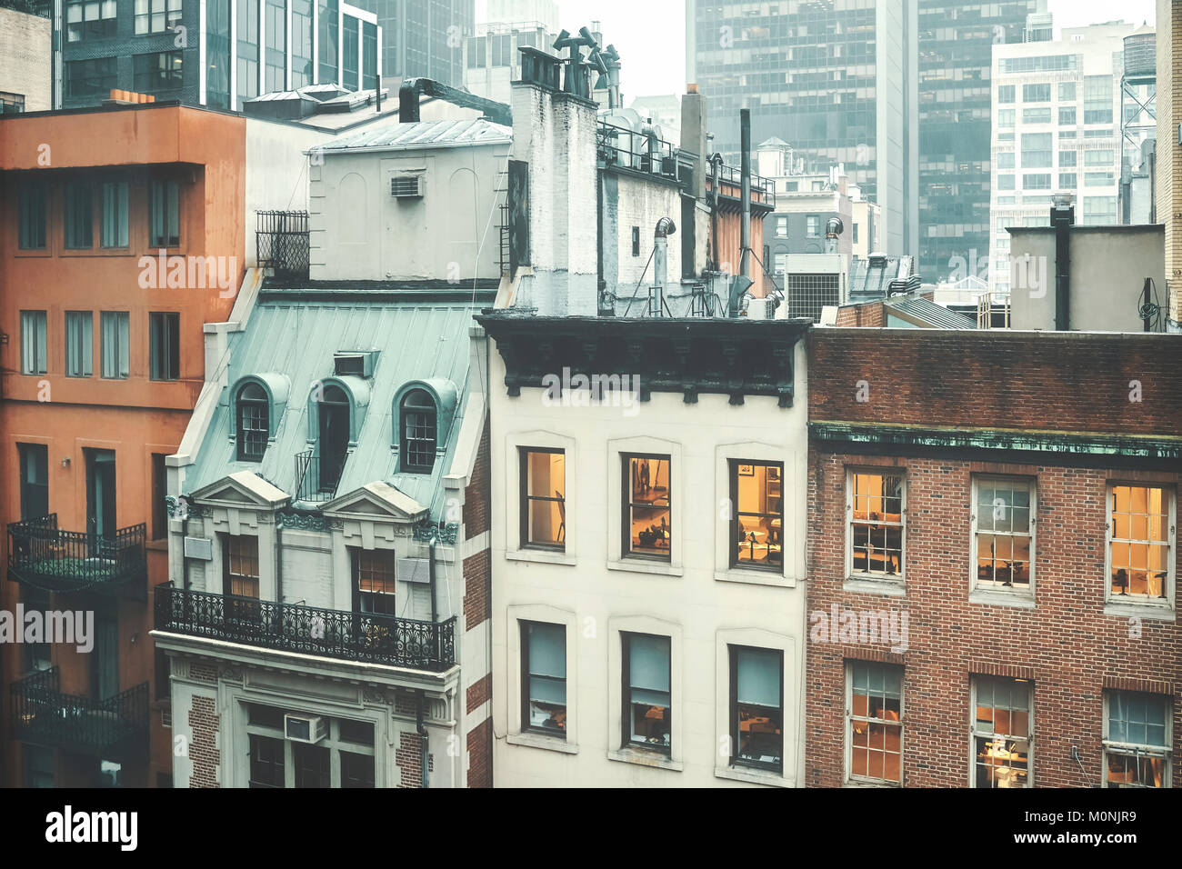 Retro photo aux tons de vieux bâtiments dans le centre de Manhattan en un jour pluvieux, New York, USA. Banque D'Images