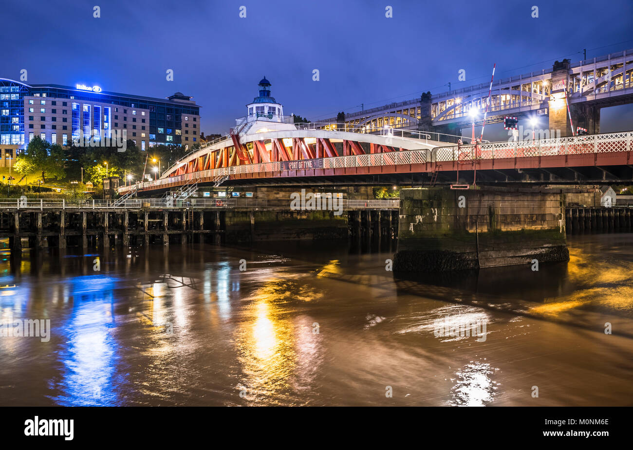 Photo de nuit du pont tournant de l'autre côté de la rivière Tyne, Newcastle-upon-Tyne, Tyne et Wear, Angleterre, avec le pont de haut niveau à l'arrière-plan. Banque D'Images