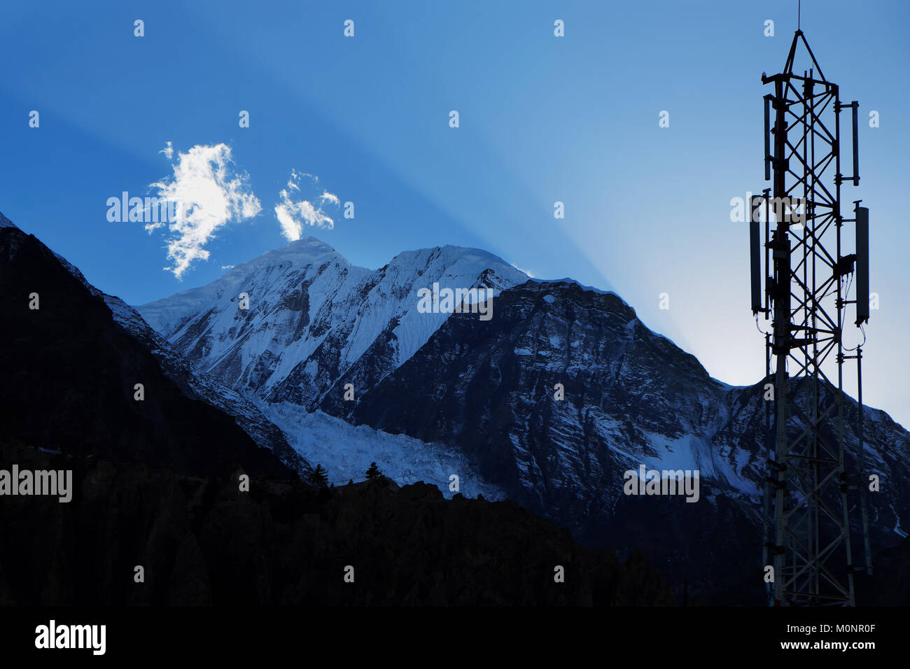 Les rayons du soleil et de l'émetteur cellulaire dans le ciel au-dessus de l'Himalaya, de l'Annapurna 2 dans la région de Manang Banque D'Images Les rayons du soleil et de l'émetteur cellulaire dans le ciel au-dessus de l'Himalaya, de l'Annapurna 2 dans la région de Manang Banque D'Images
