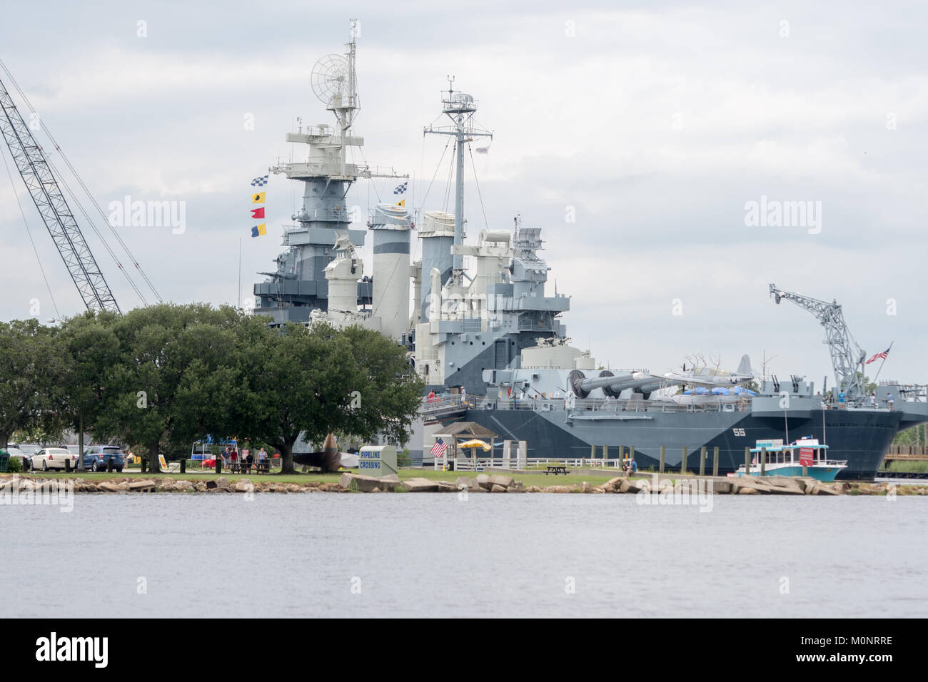 Amarré à la Cape Fear à Wilmington, Caroline du Nord, le puissant USS North Carolina touristique attend et habitants à marcher son pont Banque D'Images