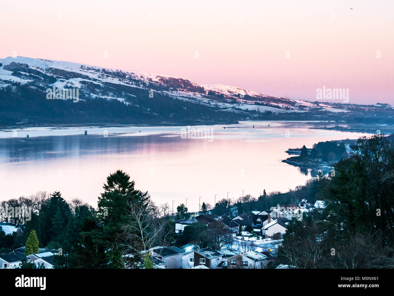 Vue du coucher de soleil à Clyde River jusqu'à partir de la colline au-dessus de Langbank en hiver, avec le calme de l'eau miroitant et pink sky, Strathclyde, Écosse, Royaume-Uni Banque D'Images