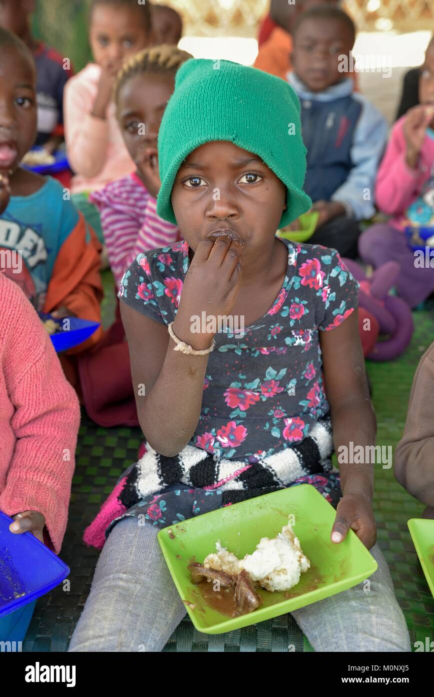 Enfant mange le riz de plaque en plastique,La Havane Soup Kitchen,préscolaire pour les orphelins,quartier Katutura à Windhoek, Khomas,Région Banque D'Images