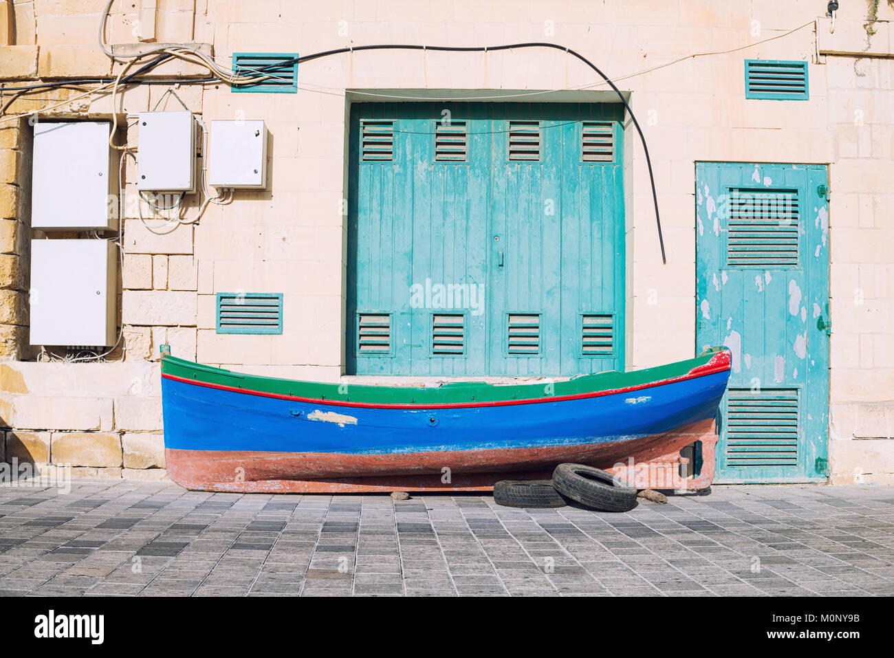 Malte colorés, pêcheur traditionnel bateau sur le trottoir en face de l'embarcadère Banque D'Images