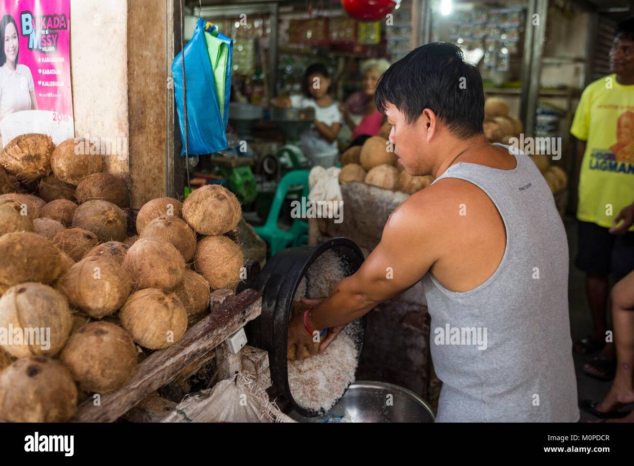 Luzon aux Philippines, la Province d'Albay,,Francois,homme de préparer le lait de coco à Tiwi market Banque D'Images