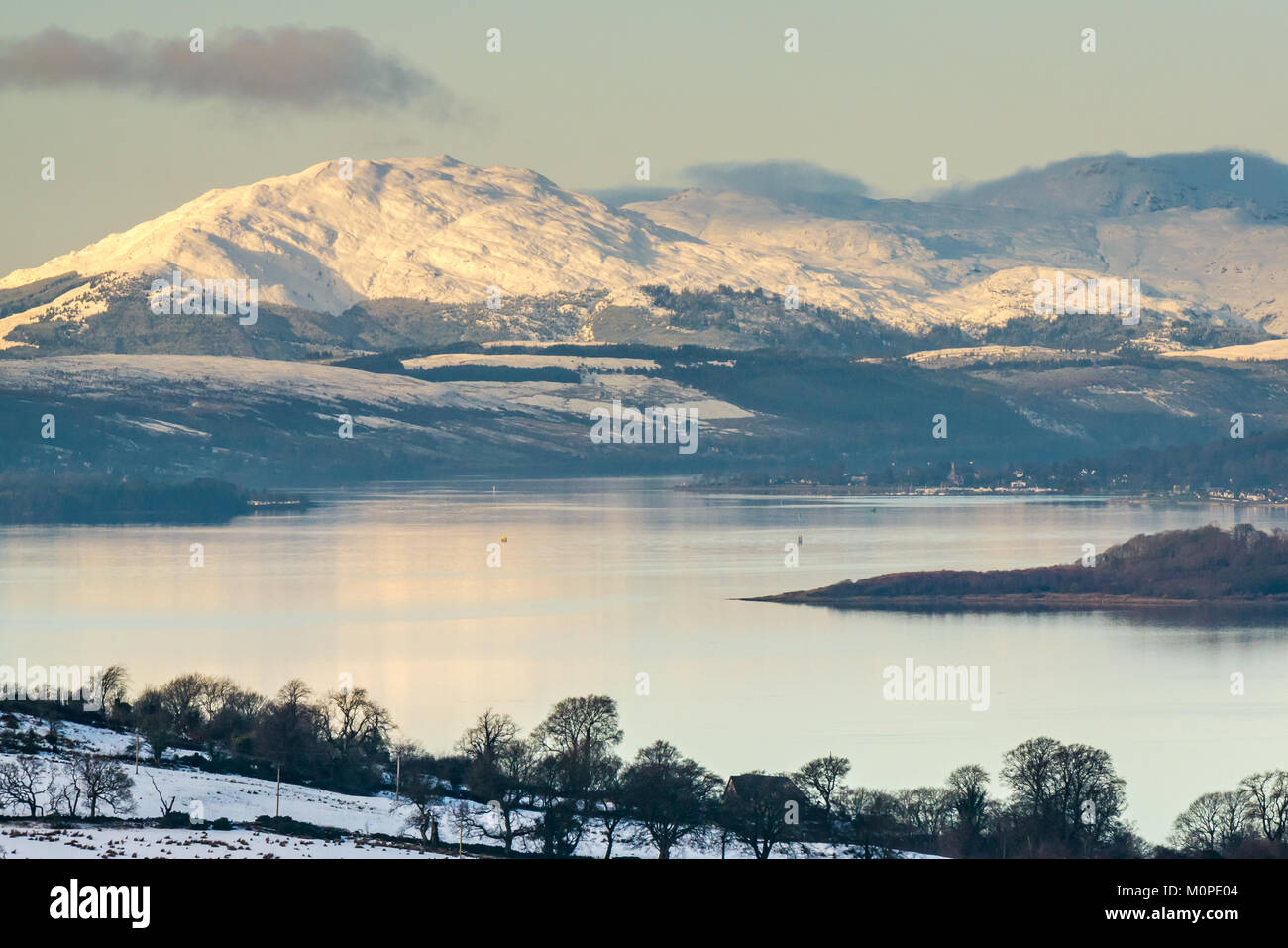 Scène d'hiver dans l'ensemble de Clyde River au-dessus de la colline de Langbank. Montagnes couvertes de neige, ciel bleu et le calme de l'eau dans la lumière du soir, Ecosse, Royaume-Uni Banque D'Images
