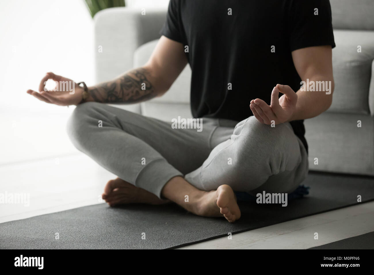 L'homme sportif en méditant la pratique du yoga dans lotus poser Banque D'Images