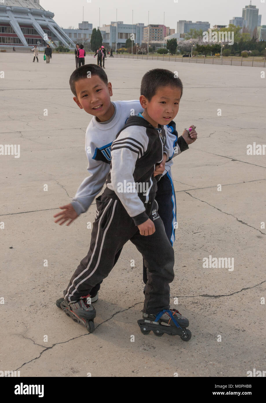 Les garçons de la Corée du nord de roller sur un carré, de la province de Pyongan, Pyongyang, Corée du Nord Banque D'Images