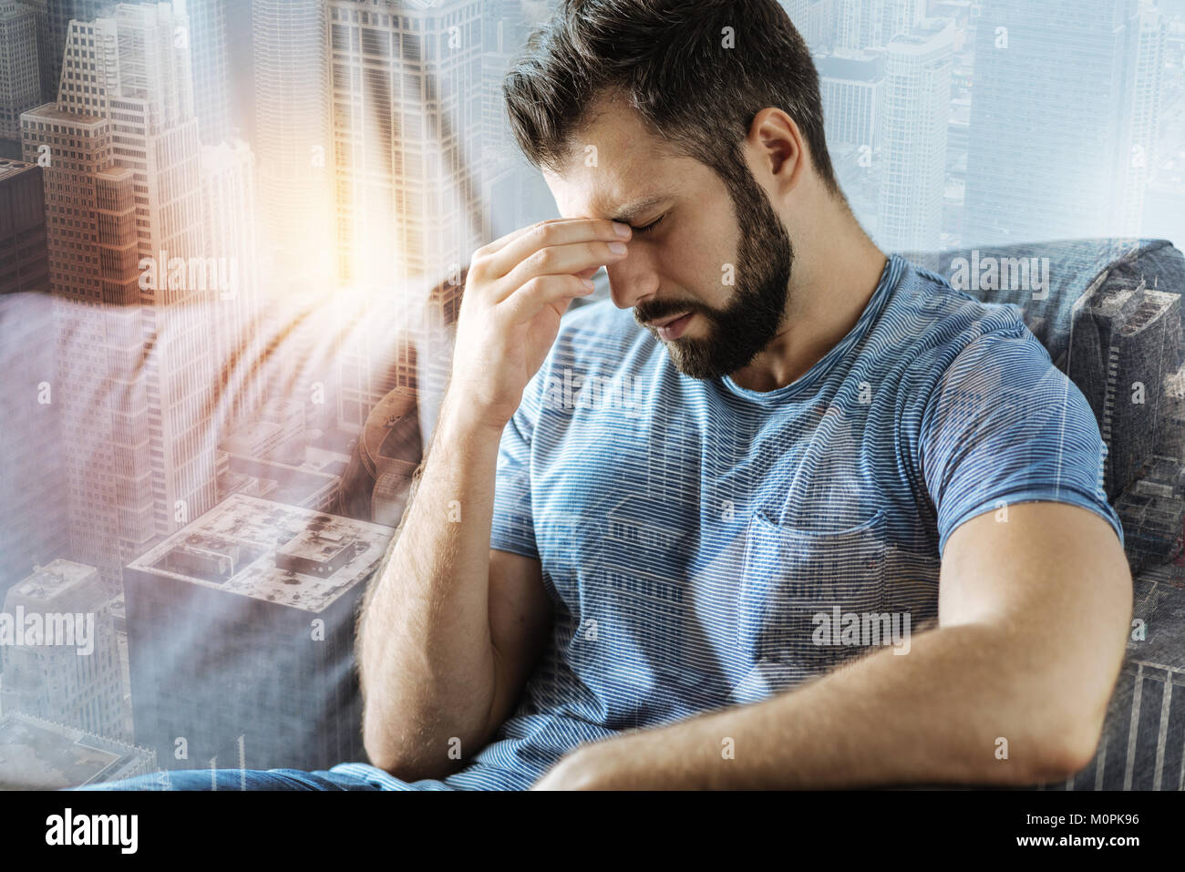 Triste homme assis et stressant d'avoir mal de tête. Banque D'Images