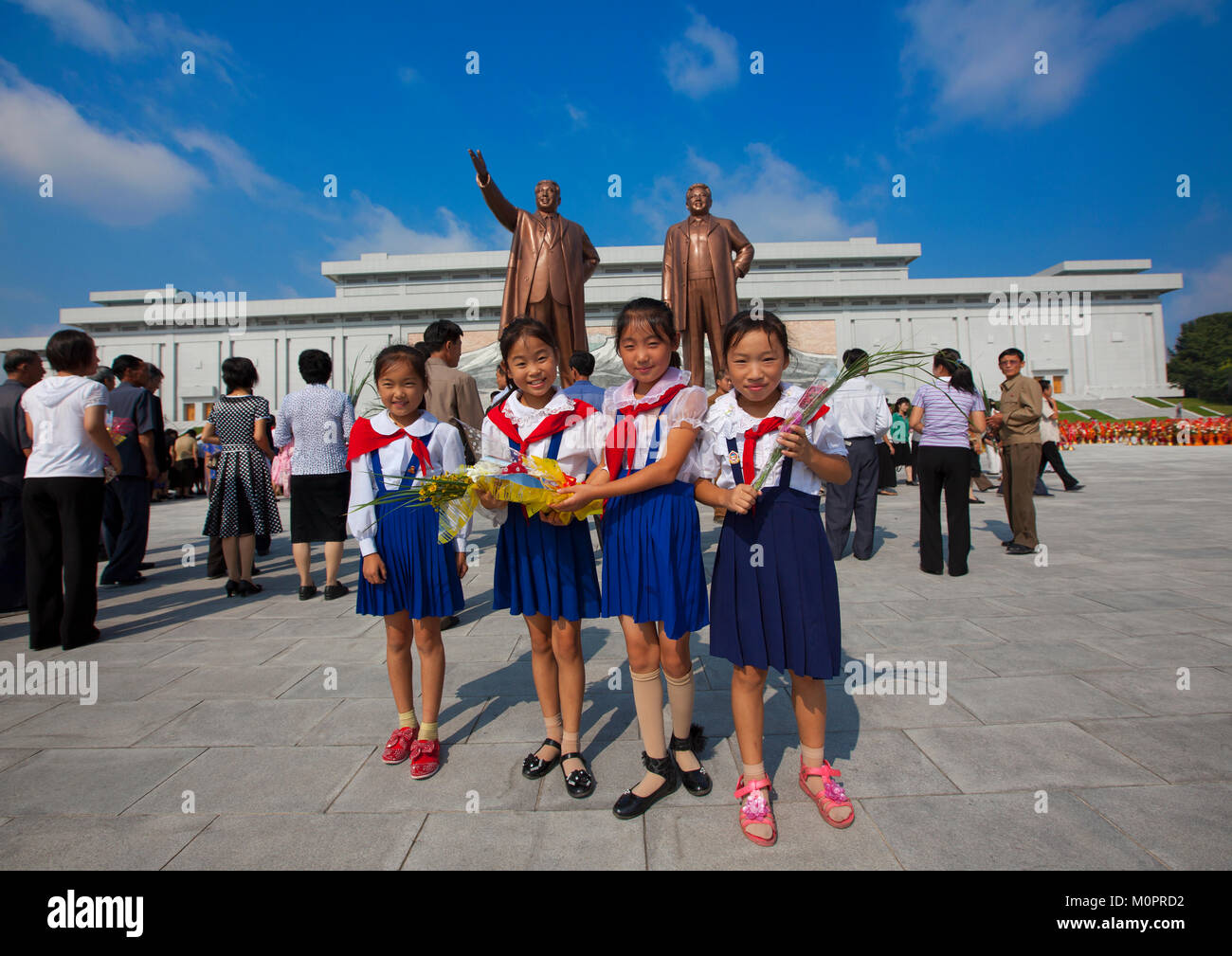 Pionniers de la Corée du Nord les filles de l'Union européenne, les enfants coréens devant les deux statues de la Chers Leaders dans le grand monument sur la colline Mansu, province de Pyongan, Pyongyang, Corée du Nord Banque D'Images