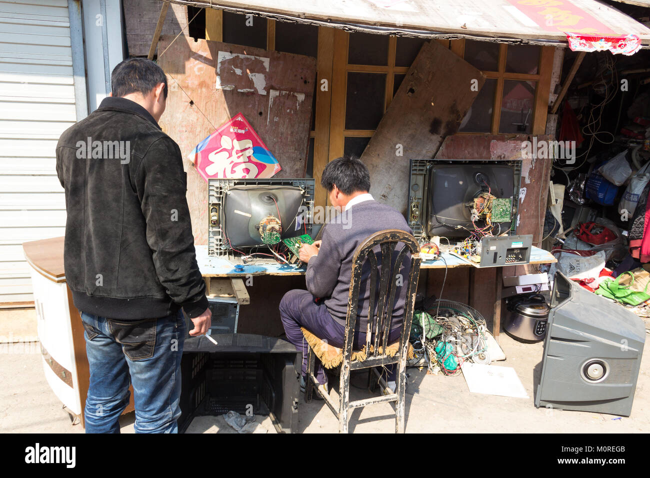 Mars 2014 - Shanghai, Chine - un homme est la réparation d'une vieille télévision cathodique dans le quartier pauvre de Shandongtou Banque D'Images