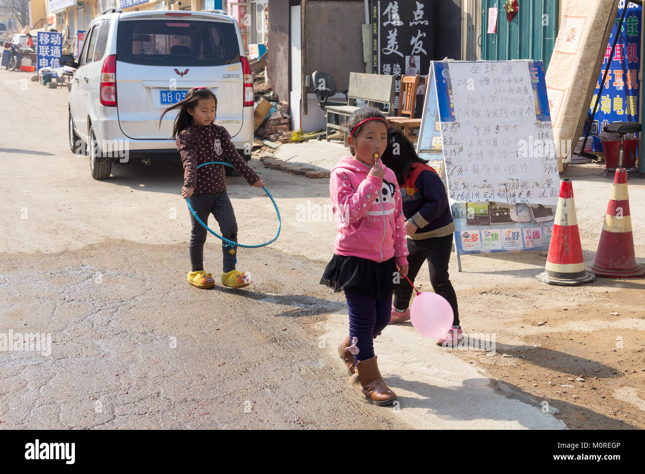 Mars 2014 - Shanghai, Chine - Enfants jouant dans la rue dans le quartier pauvre de Shandongtou Banque D'Images