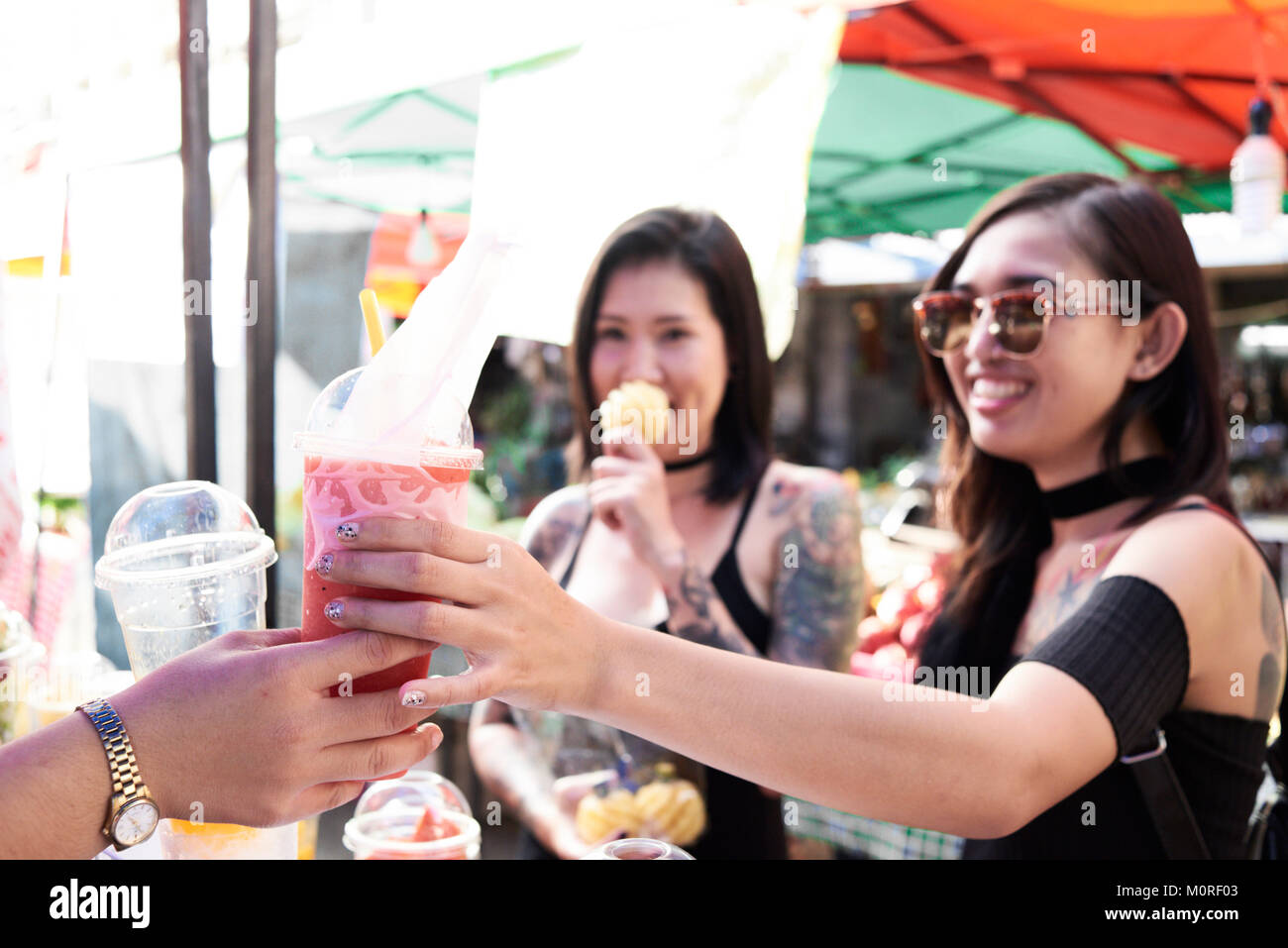 Asian girl friends acheter un smoothie dans un magasin de rue en Thaïlande. Banque D'Images