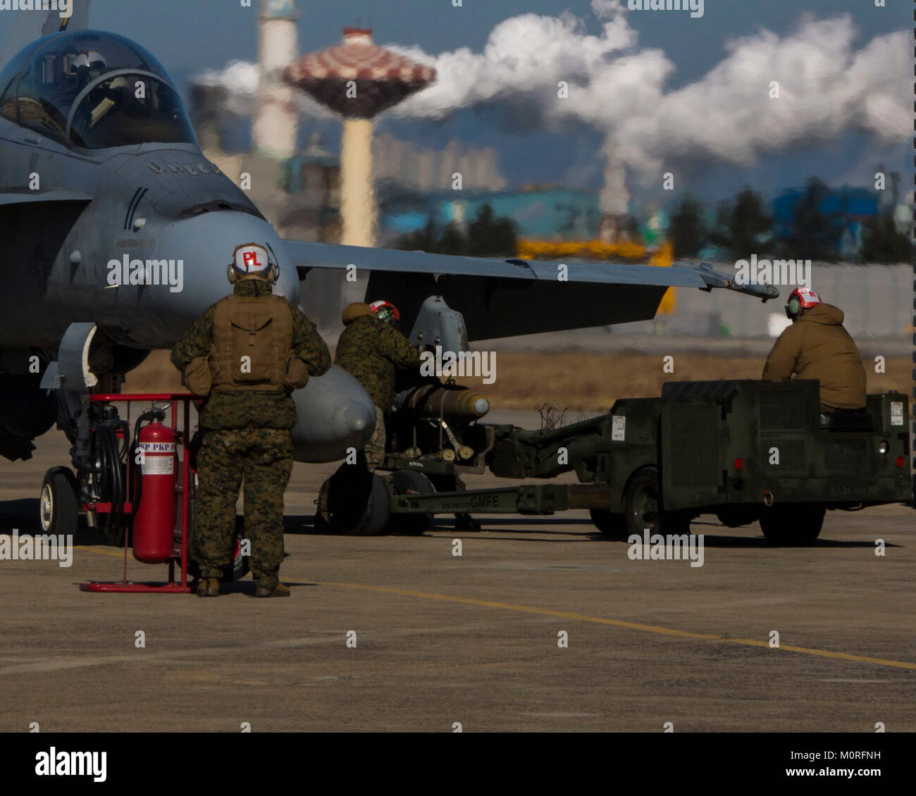 Les Marines américains avec Marine (Escadron d'attaque de chasseurs tout temps VMFA) 242 Technicien de munitions de l'aviation, l'équipe de charge à chaud un MK-82 High Explosive bombe à usage général sur un Corps des Marines américains F/A- 18D Hornet, aussi avec VMFA(AW)-242, pendant l'avitaillement en carburant et fosse à chaud hot-reload formation au Naval Air Station Pohang, République de Corée, le 12 décembre 2017. Le but de l'exercice était de montrer que les Marines pourraient effectivement constituer un point de ravitaillement et l'armement de l'avant avec des entités et la conduite des évolutions de la formation à l'étranger. (U.S. Marine Corps Banque D'Images