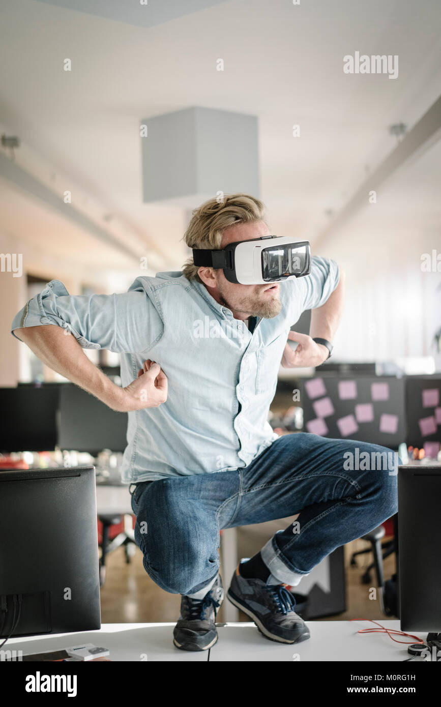 Businessman wearing glasses VR dans office faisant semblant d'être un singe Banque D'Images