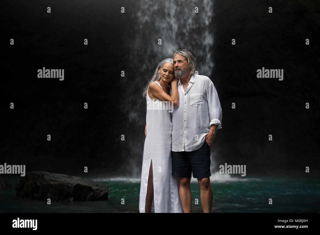 Romantic couple standing in front of cascade tropicale Banque D'Images Romantic couple standing in front of cascade tropicale Banque D'Images