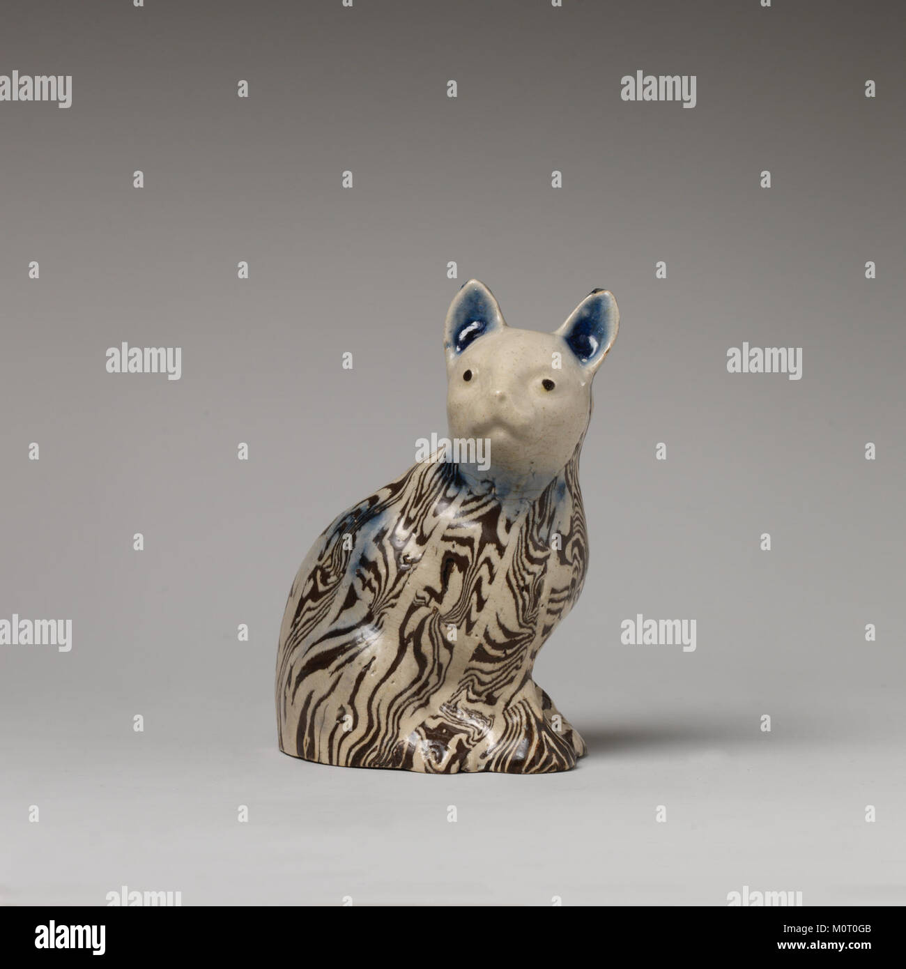 Cet artefact est une figurine de chat de la collection MET, mettant en valeur un savoir-faire complexe. Le chat, une représentation de la forme féline, est probablement issu de civilisations anciennes, reflétant l'importance culturelle dans l'art et l'iconographie. Banque D'Images