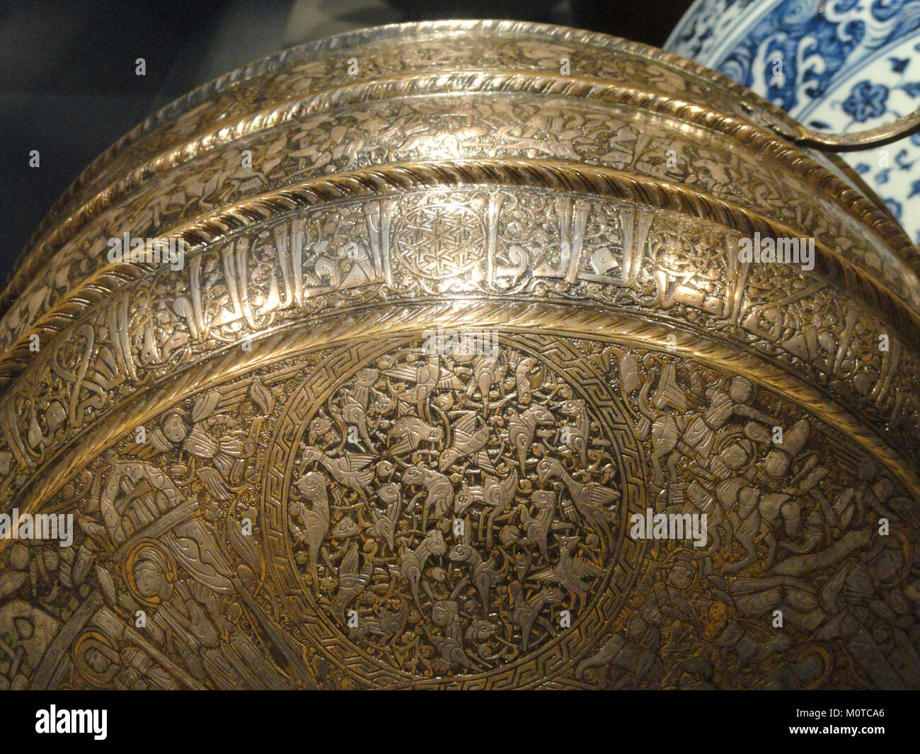 Cette cantine du XIIIe siècle, originaire du nord de l'Irak, présente des motifs chrétiens et islamiques complexes, soulignant les échanges culturels de l'époque. Réalisée en laiton incrusté d’argent, la cantine est un remarquable exemple de l’artisanat médiéval. L'objet est logé dans la Freer Gallery of Art. Banque D'Images