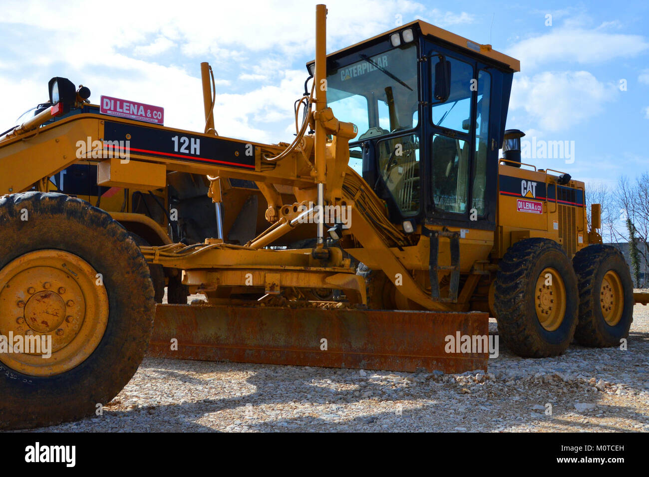 La niveleuse 12 H Caterpillar, équipée d'une lame, est un véhicule de construction extra-robuste conçu pour le nivellement et le nivellement des surfaces. Il est couramment utilisé dans les projets de construction et d'entretien de routes. Banque D'Images