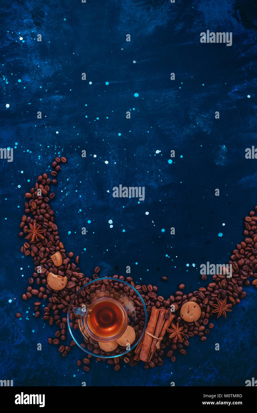 Vignette semi-circulaire avec verre tasse à expresso, la cannelle, l'anis étoile, cookies et dispersés les grains de café. Ingrédients café créative mise à plat avec le co Banque D'Images