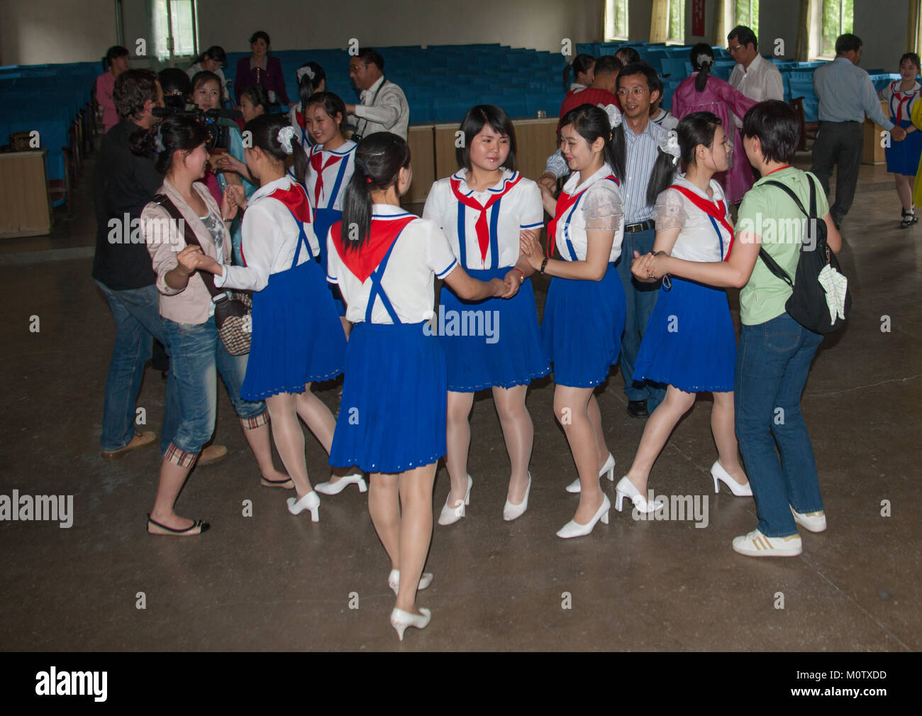 Pionnier nord-coréen filles dansant avec les touristes dans une école, de la province de Pyongan, Pyongyang, Corée du Nord Banque D'Images