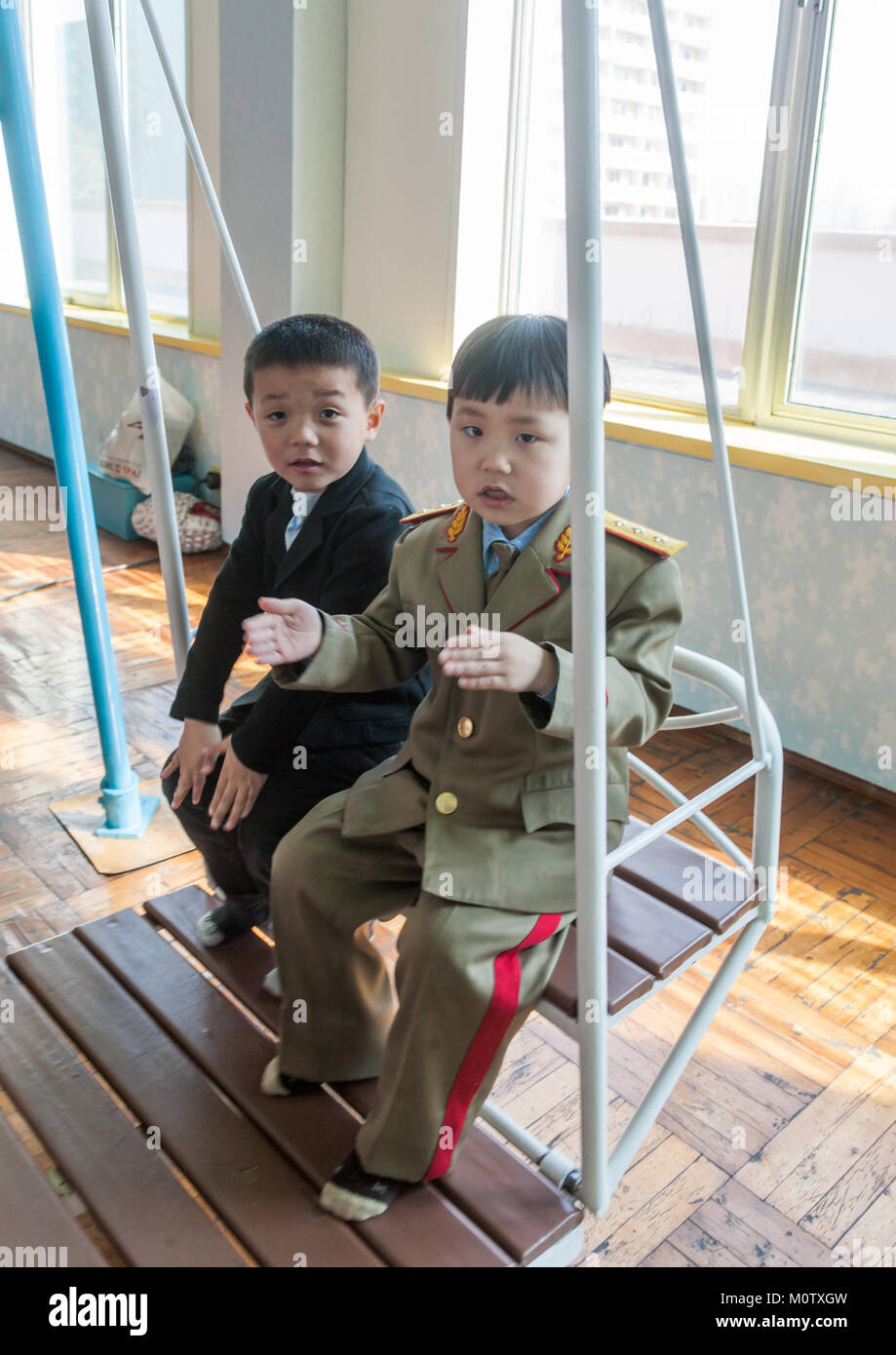 Les garçons de la Corée du Nord se balançant dans l'école primaire Kwangbok, province de Pyongan, Pyongyang, Corée du Nord Banque D'Images