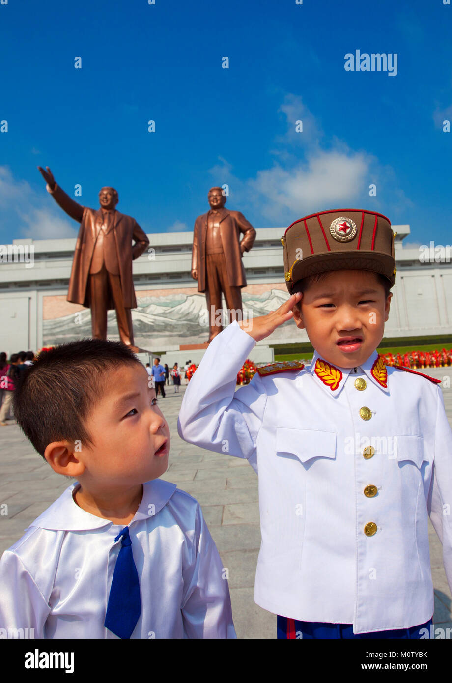 Garçon nord-coréen habillé en soldat devant les deux statues de la Chers Leaders dans le grand monument sur la colline Mansu, province de Pyongan, Pyongyang, Corée du Nord Banque D'Images