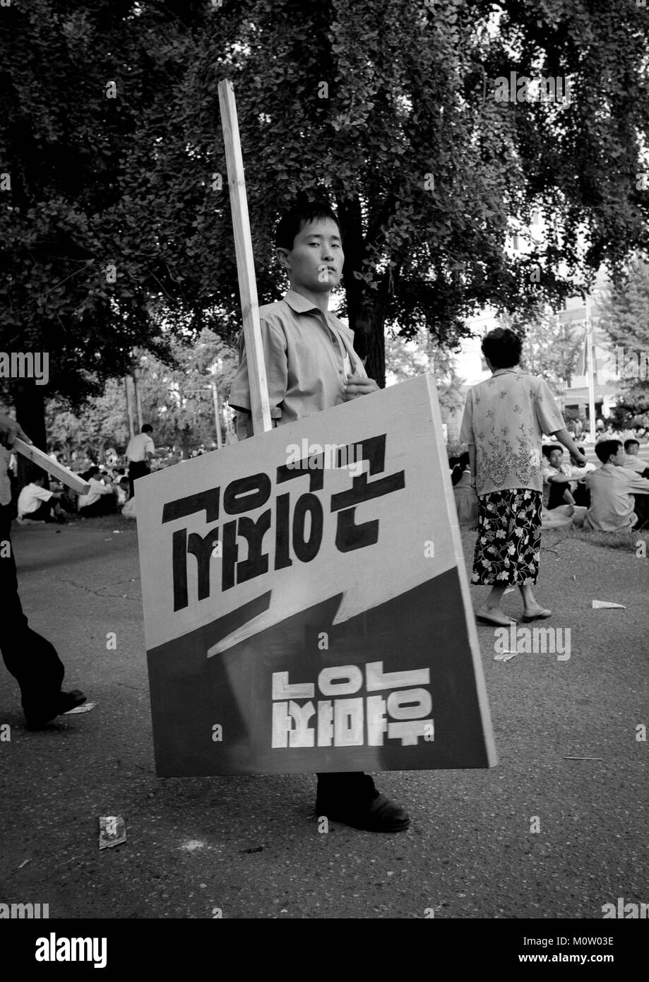 L'homme en Corée du Nord portant un panneau de propagande dans la rue, de la province de Pyongan, Pyongyang, Corée du Nord Banque D'Images