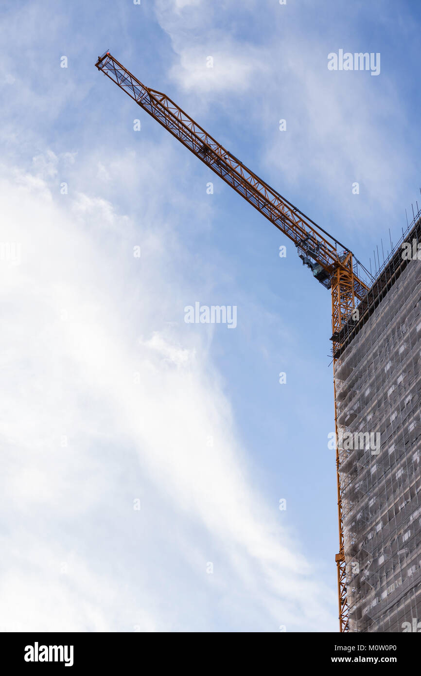 Une grue sur le haut d'un bloc d'appartements Banque D'Images