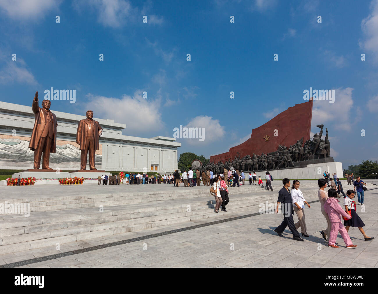 Les gens de la Corée du Nord devant les statues de la troupe artistique Mansudae Chers dirigeants de grand monument, de la province de Pyongan, Pyongyang, Corée du Nord Banque D'Images