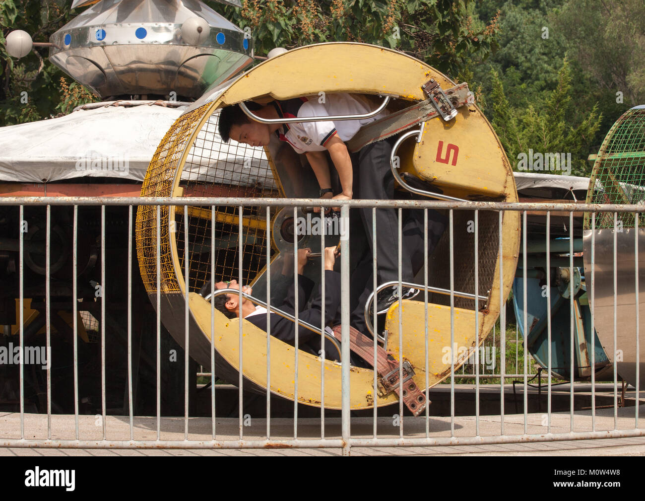 Les garçons de la Corée du Nord dans une ancienne attraction de Taesongsan fête foraine, de la province de Pyongan, Pyongyang, Corée du Nord Banque D'Images